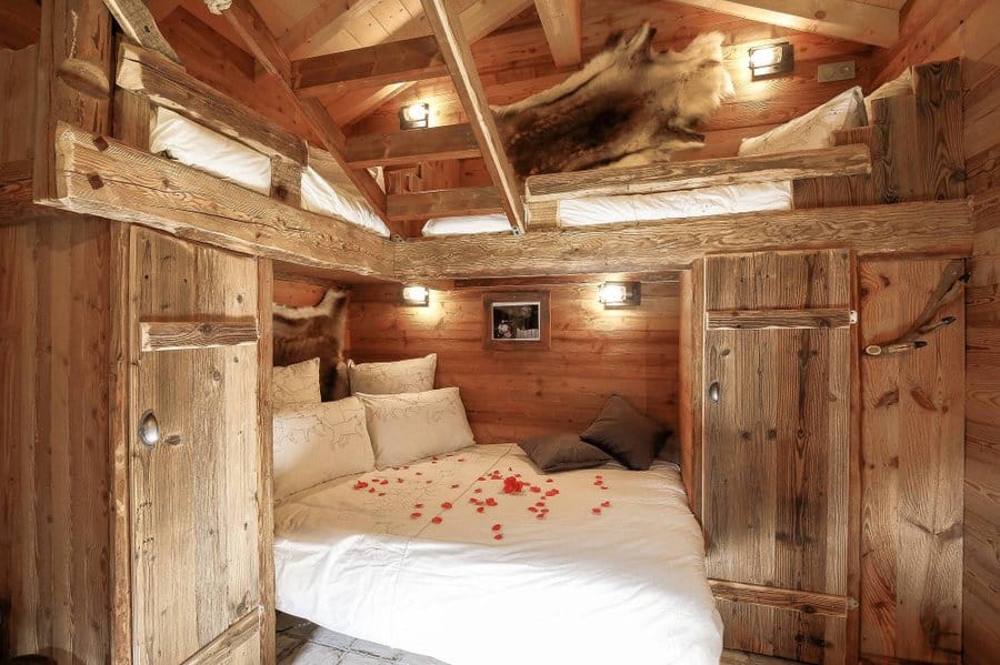 lit double et deux lit simple au dessus dans la mezzanine à l'intérieur d'un chalet.
