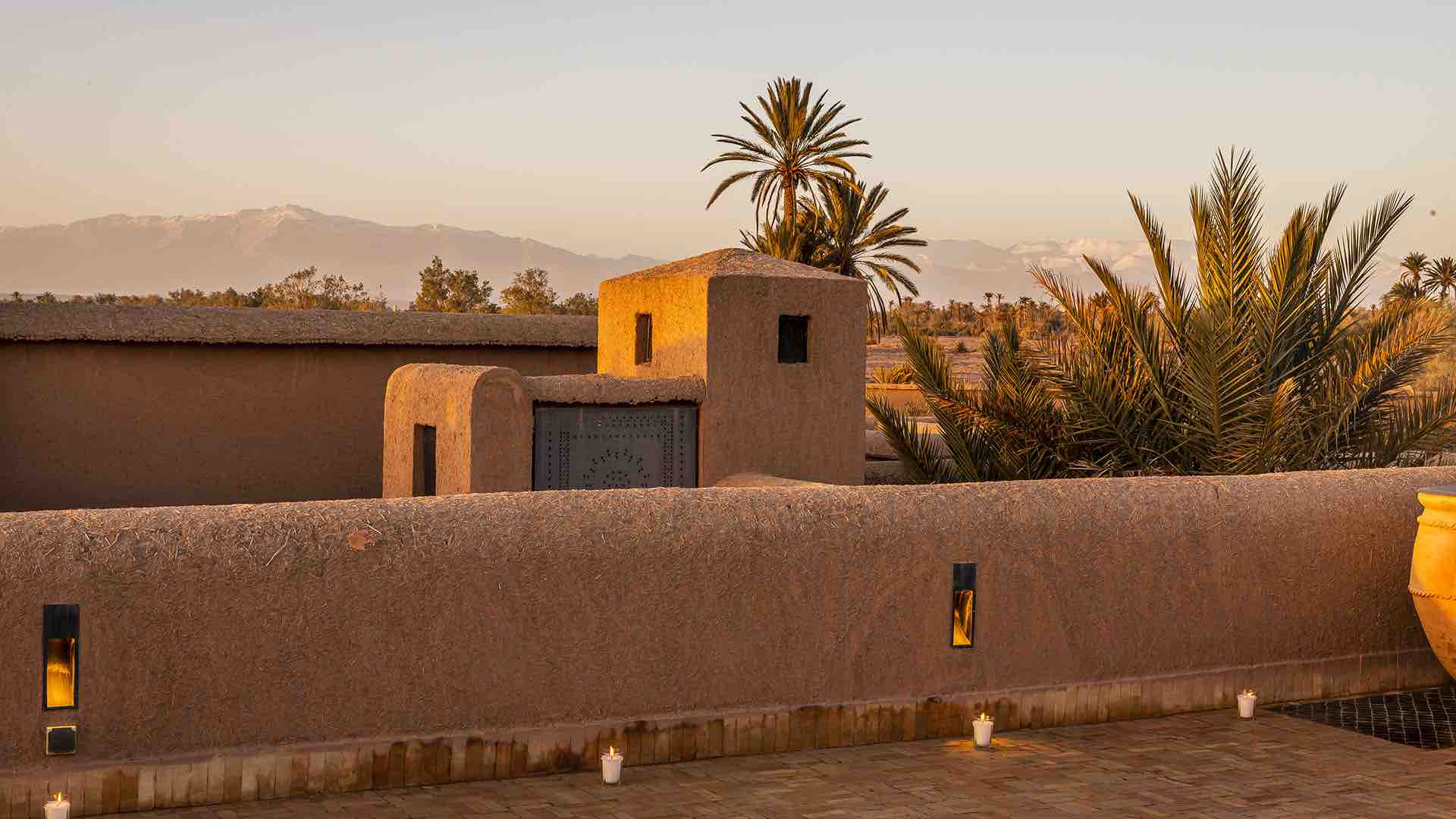 photo vue sur l'atlas depuis la villa au maroc. des palmiers sont au premier plan