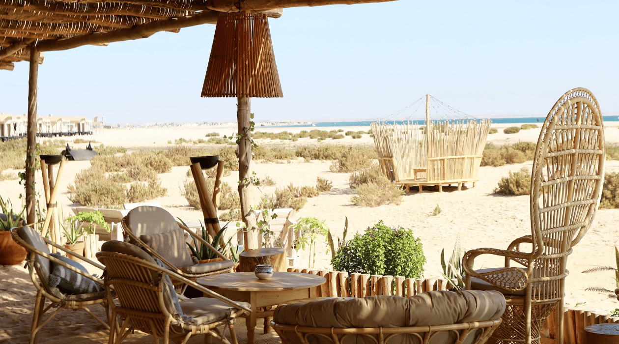 Canapé et chaise sous un porche extérieur avec une vue face a la mer