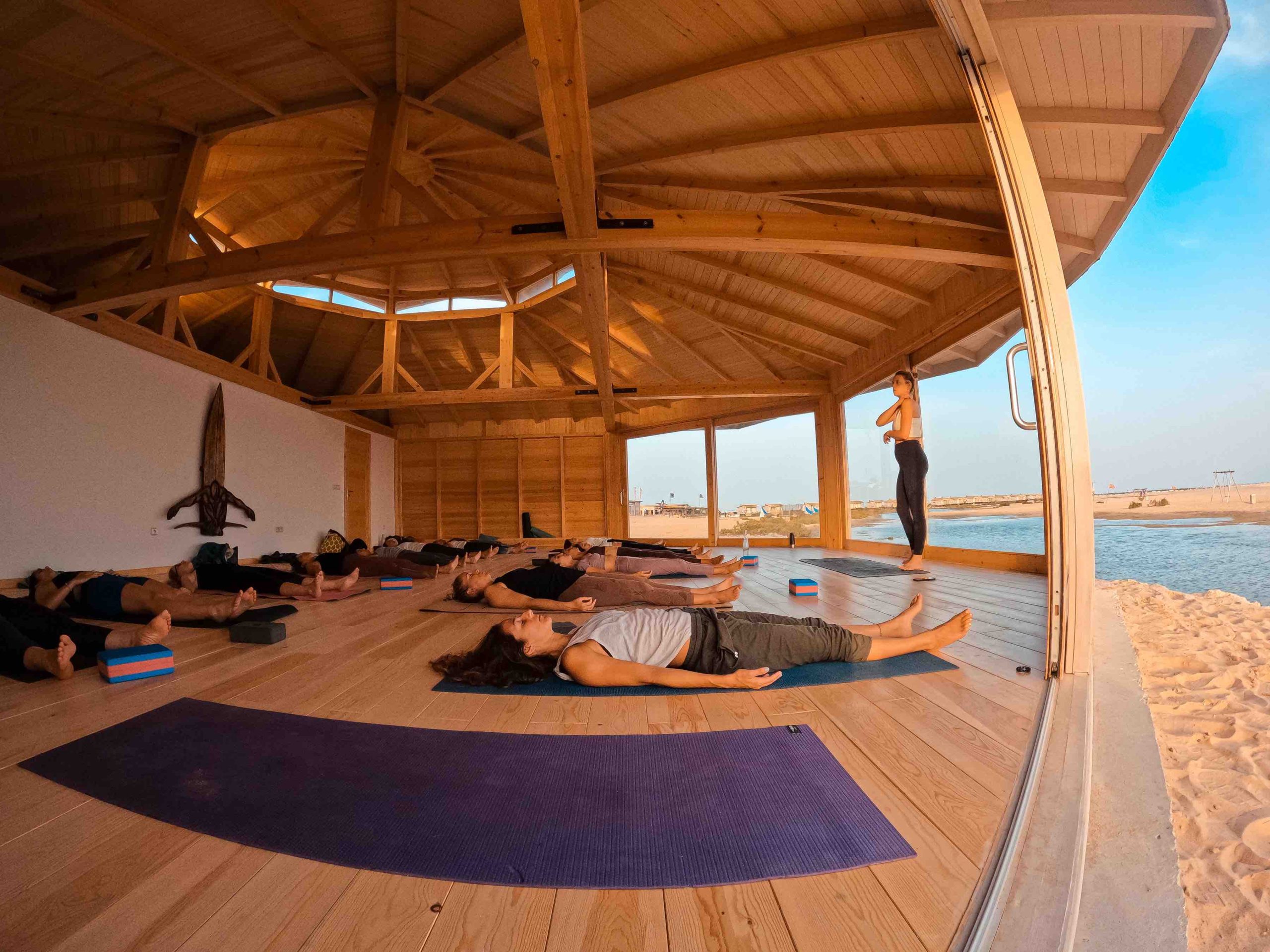 espace yoga avec élèves et professeurs en train de pratiquer face à l'océan
